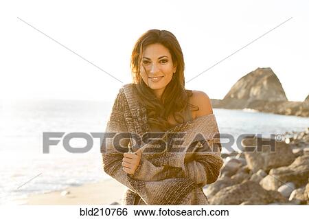 Woman wrapped in sweater on beach View Large Photo Image Stock Photograph - Woman wrapped in sweater on beach. Fotosearch