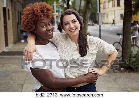 Women hugging on city street View Large Photo Image Stock Image - Women hugging on city street. Fotosearch