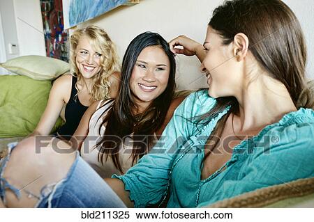 Women relaxing together on sofa View Large Photo Image Stock Photography - Women relaxing together on sofa. Fotosearch