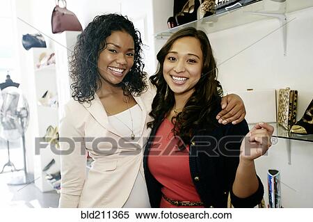 Stock Photography - Women shopping together in shoe store. Fotosearch