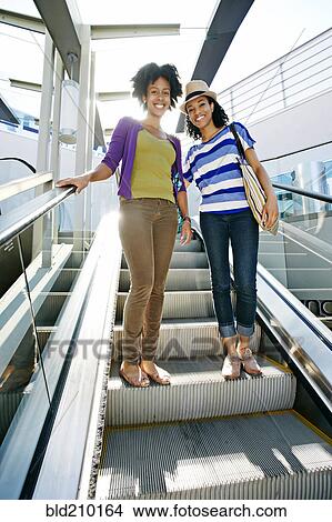 Picture - Women smiling together at outdoor mall. Fotosearch