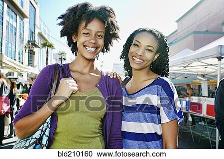 Women smiling together at outdoor market View Large Photo Image Stock Image - Women smiling together at outdoor market. Fotosearch