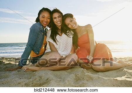 Stock Photo - Women smiling together on beach. Fotosearch