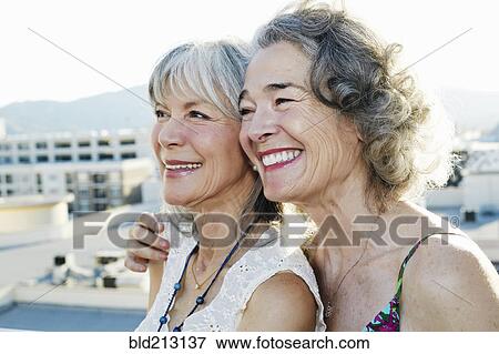 Women smiling together on urban rooftop View Large Photo Image Stock Photo - Women smiling together on urban rooftop. Fotosearch