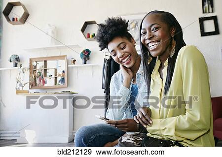 Women using cell phone in store View Large Photo Image Stock Photo - Women using cell phone in store. Fotosearch