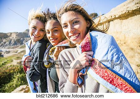Stock Photograph - Women wrapped in blanket on rural hillside. Fotosearch