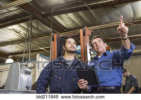Worker and businessman talking in warehouse View Large Photo Image Stock Photo - Worker and businessman talking in warehouse. Fotosearch