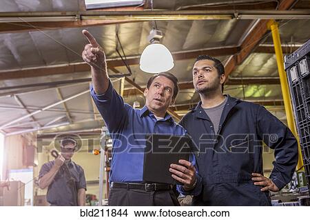 Picture - Worker and manager talking in warehouse. Fotosearch
