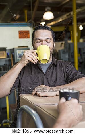 Worker drinking coffee in warehouse View Large Photo Image Stock Photography - Worker drinking coffee in warehouse. Fotosearch