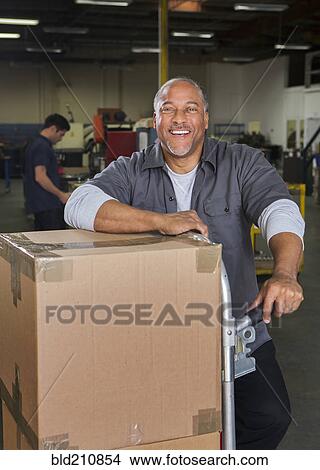 Picture - Worker smiling in warehouse. Fotosearch