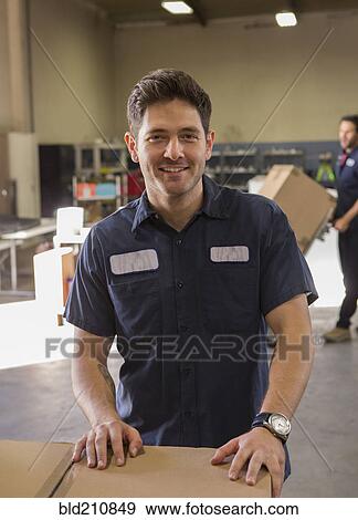 Worker smiling in warehouse View Large Photo Image Stock Photo - Worker smiling in warehouse. Fotosearch