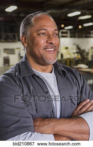 Stock Photo - Worker smiling in warehouse. Fotosearch