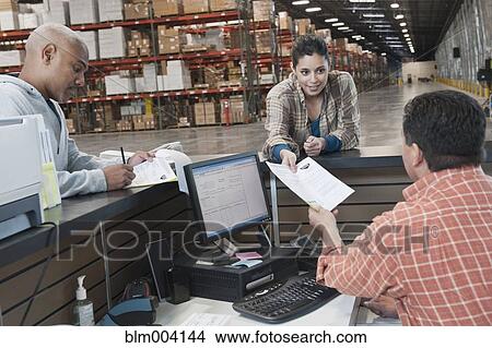 Workers completing paperwork in warehouse View Large Photo Image Picture - Workers completing paperwork in warehouse. Fotosearch