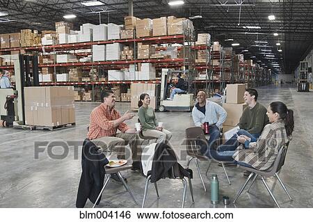 Workers enjoying coffee break in warehouse View Large Photo Image Stock Photograph - Workers enjoying coffee break in warehouse. Fotosearch