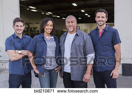 Stock Image - Workers smiling outside warehouse. Fotosearch