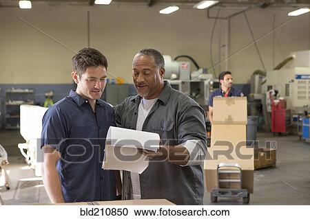 Workers talking in warehouse View Large Photo Image Stock Image - Workers talking in warehouse. Fotosearch