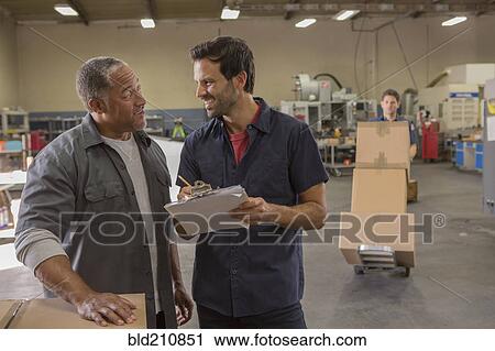 Workers talking in warehouse View Large Photo Image Stock Image - Workers talking in warehouse. Fotosearch