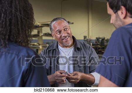 Stock Photo - Workers talking in warehouse. Fotosearch