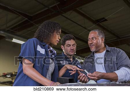 Stock Photo - Workers talking in warehouse. Fotosearch