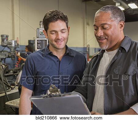 Workers talking in warehouse View Large Photo Image Stock Photograph - Workers talking in warehouse. Fotosearch