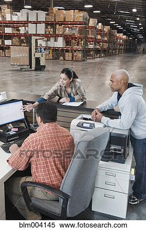 Workers using computer in warehouse View Large Photo Image Stock Photography - Workers using computer in warehouse. Fotosearch