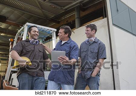 Workers using digital tablet at warehouse loading dock View Large Photo Image Stock Image - Workers using digital tablet at warehouse loading dock. Fotosearch