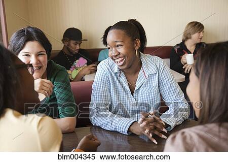 Young women sitting at table in diner View Large Photo Image Stock Photography - Young women sitting at table in diner. Fotosearch