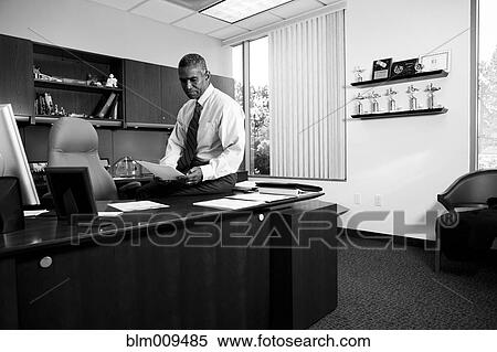 African American businessman sitting on desk View Large Photo Image Stock Photography - African American businessman sitting on desk. Fotosearch