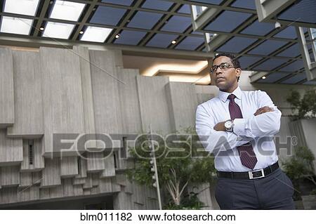 Stock Image - African American businessman standing in lobby. Fotosearch