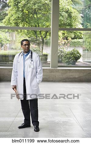 Stock Photo - African American doctor standing in lobby. Fotosearch