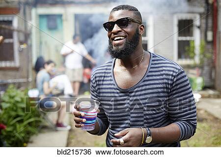 African American man drinking at backyard barbecue View Large Photo Image Stock Photograph - African American man drinking at backyard barbecue. Fotosearch