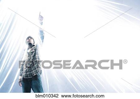Stock Image - African American man pointing at light spark. Fotosearch
