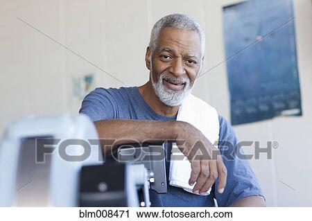 Stock Image - African American man sitting in health club. Fotosearch
