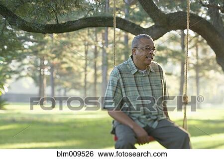 African American man sitting on swing View Large Photo Image Stock Photograph - African American man sitting on swing. Fotosearch
