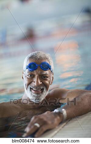 Picture - African American man swimming in swimming pool. Fotosearch