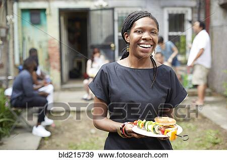 African American woman eating at backyard barbecue View Large Photo Image Stock Photo - African American woman eating at backyard barbecue. Fotosearch