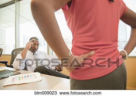 Stock Image - Angry Black businesswoman talking to co-worker in conference room. Fotosearch