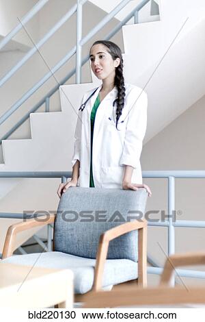 Stock Image - Armenian doctor standing at armchair. Fotosearch