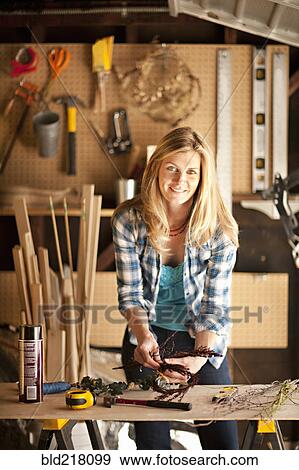 Stock Photo - Artisan working in garage workshop. Fotosearch