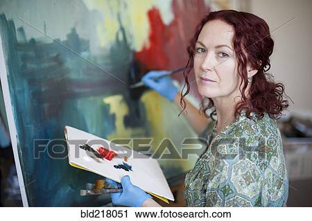 Artist painting on canvas in studio View Large Photo Image Stock Image - Artist painting on canvas in studio. Fotosearch