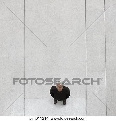 Picture - Asian businessman standing in lobby. Fotosearch