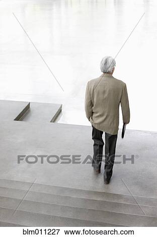 Stock Photo - Asian businessman walking down steps. Fotosearch