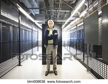 Stock Photo - Asian businessman working in office technology room. Fotosearch