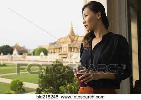 Asian businesswoman admiring view from cafe window, Phnom Penh, Cambodia View Large Photo Image Stock Photo - Asian businesswoman admiring view from cafe window, Phnom Penh, Cambodia. Fotosearch
