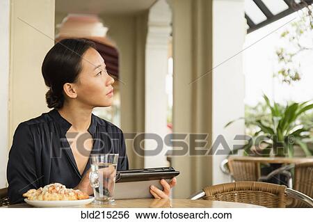 Asian businesswoman using digital tablet in cafe View Large Photo Image Stock Photograph - Asian businesswoman using digital tablet in cafe. Fotosearch