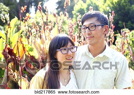 Stock Photography - Asian couple hugging outdoors. Fotosearch