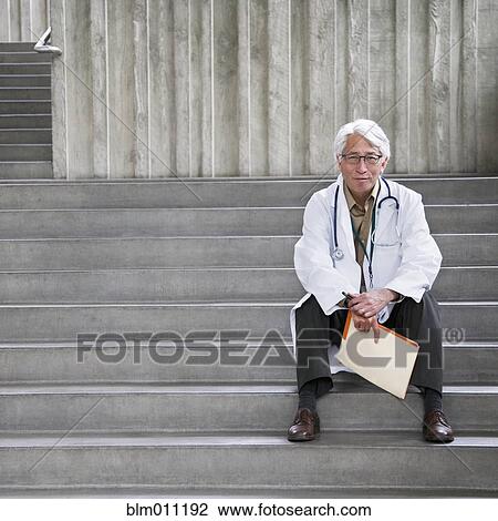 Asian doctor sitting outdoors on steps View Large Photo Image Stock Image - Asian doctor sitting outdoors on steps. Fotosearch