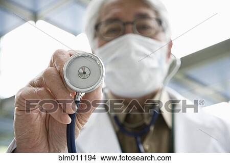 Picture - Asian doctor using stethoscope. Fotosearch