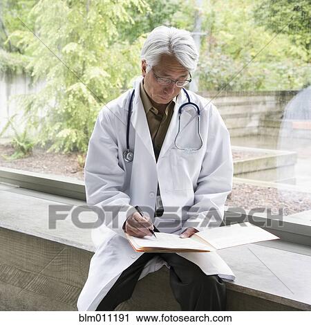 Asian doctor writing in medical record View Large Photo Image Stock Image - Asian doctor writing in medical record. Fotosearch
