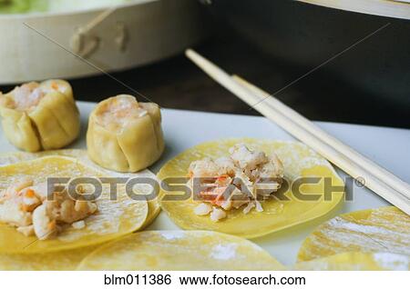 Stock Photograph - Asian dumplings in process of being made. Fotosearch
